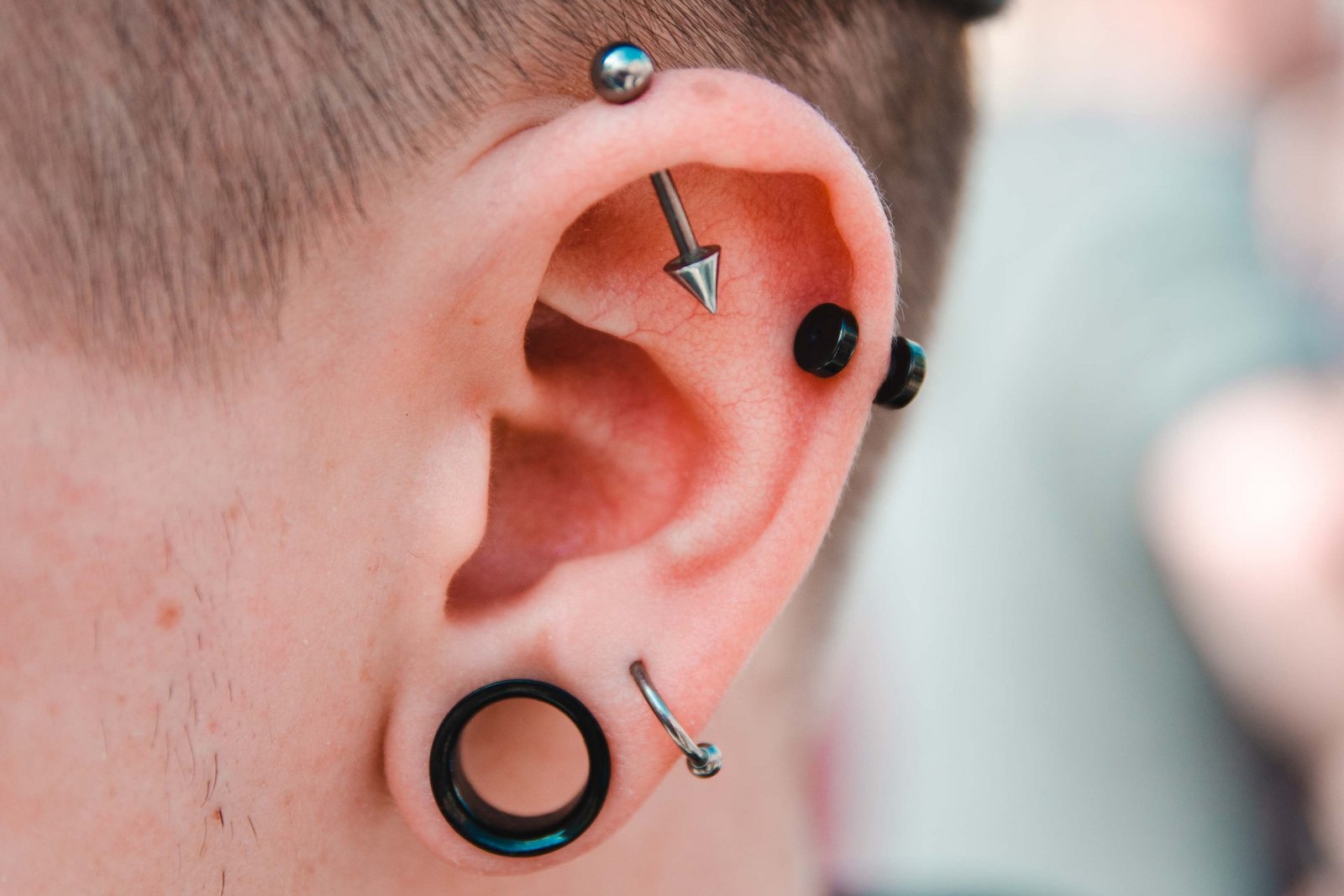 Moški s številnimi piercingi v ušesu