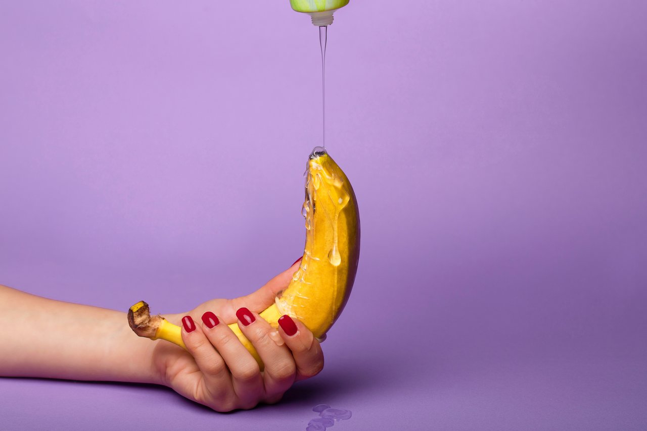 Mazivo se prelije po banani, ki jo držite z eno roko.